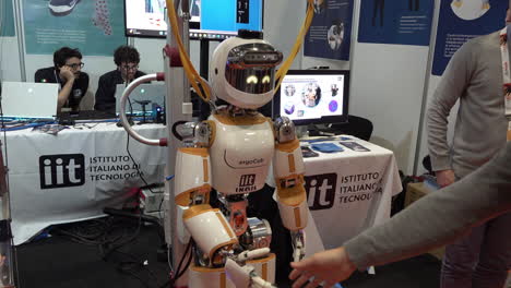 Ein-Mann-Schüttelt-Einem-Humanoiden-Roboter-Auf-Der-Konferenz-Der-IEEE-Robotics-And-Automation-Society-Im-Excel-Center-Die-Hand
