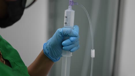 nurse-administering-anesthesia-with-syringe,-in-hospital-in-operating-room