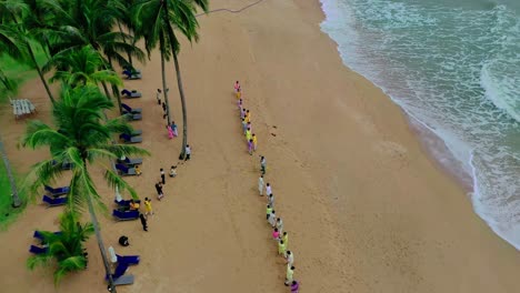Many-people-dressed-in-colorful-clothes-are-divided-into-two-teams-and-are-playing-a-game-of-tug-of-war-against-each-other-on-the-beach