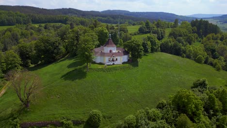 Belief-in-God-Wonderful-aerial-top-view-flight-Round-Chapel-on-mountain-hill,-Krumlov-Czech-Republic-Summer-2023