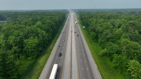 Aerial-dolly-forward-over-6-lane-highway-in-woodlands-in-USA