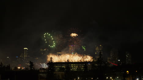 Dramatic-sparkling-golden-fireworks-explode-over-night-city-skyline