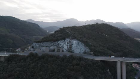 Filmische-Luftaufnahme-Des-Verkehrs,-Der-über-Eine-Hohe-Viaduktüberführung-In-Der-Italienischen-Landschaft-Fährt