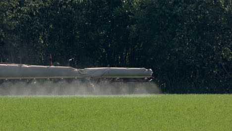 Sprayer-tractor-spraying-herbicides-on-crops-on-farm-land,-slow-motion