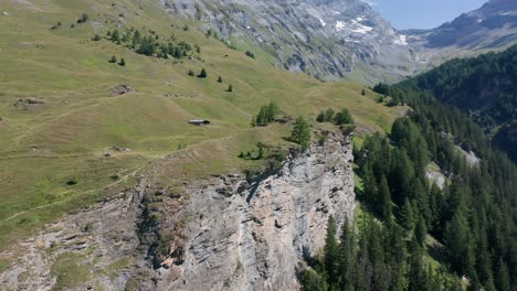 Aerial-of-high-mountain-ledge-with-small-cottages-in-Swiss-countryside