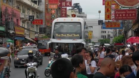 People-Crowd-the-Streets-of-Yaowarat-Road-in-Chinatown-with-Passing-Tour-Bus-in-Thailand