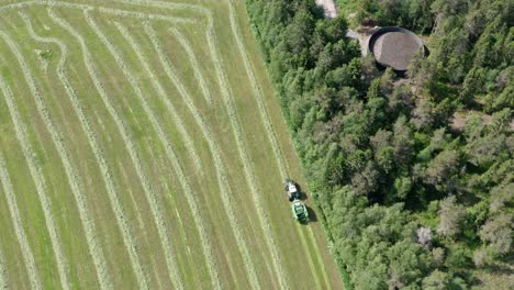 Tractor-Mowing-A-Green-Fresh-Grass-Field---drone-shot