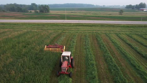Utilizando-Una-Hileradora-Hyrdoswing,-Un-Agricultor-De-Wisconsin-Corta-Un-Campo-De-Alfalfa-Y-Pasto.