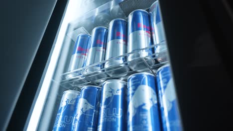 Imágenes-Tomadas-En-Mano-De-Latas-De-Red-Bull-En-Una-Nevera-De-Red-Bull-En-Un-Ambiente-Oscuro