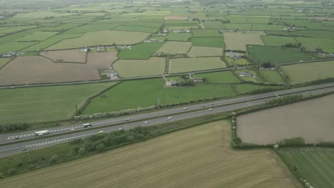 Tráfico-Sobre-La-Ruta-De-La-Autopista-N7-Con-Tierras-De-Cultivo-En-El-Condado-De-Laoise,-Irlanda