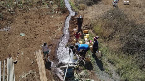 Massai-Leute-Füllen-Plastikkrüge-Mit-Trinkwasser-Aus-Bohrlochbrunnen,-Loitokitok,-Kenia