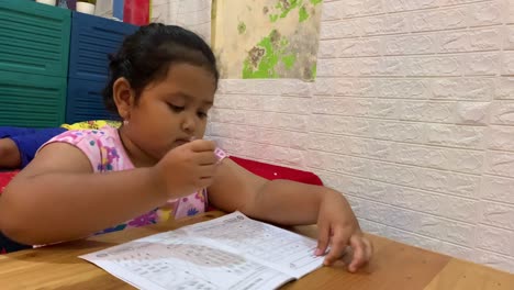 Asiatisches-Kleines-Mädchen,-Das-Zu-Hause-Auf-Dem-Tisch-Lernt