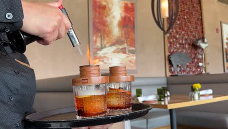 Barkeeper-Flammt-Hickory-Rauch-In-Hochwertige-Whisky-Cocktailgetränke-Mit-Einer-Feurigen-Lötlampe