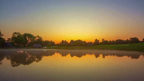 Mirror-Reflections-On-A-Misty-Lake-With-Golden-Horizon-At-Dusk-Till-Dawn