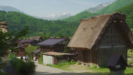 Traditional-Gassho-Zukuri-Thatched-Roof-Home-In-Shirakawago-With-Shokawa-Valley-In-Background