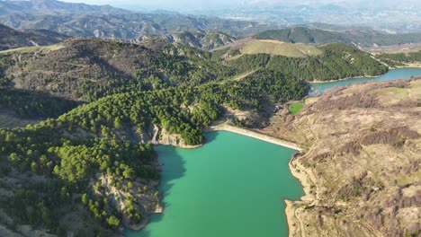 Aerial-Shot-of-mountain-river-closed-up-with-a-dam