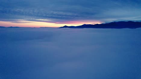 Aerial-Drone-Fly-Above-Clouds,-Sunrise-in-Andean-Cordillera,-Santiago-Chile-Sun-Shines-Behind-Cloudy-Sky-and-Andes-Mountain-Range