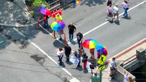 Toma-Aérea-De-Arriba-Hacia-Abajo-De-Manifestantes-Con-Carteles-Religiosos-Cristianos-En-La-Entrada-Del-Festival-Del-Desfile-Del-Orgullo-Lesbiano-Gay-Bi-Trans-Queer-En-La-Ciudad-Americana