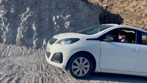 Peugeot-108-Fährt-An-Einem-Sonnigen-Tag-Auf-Santorini-Eine-Steile-Bergstraße-Hinauf