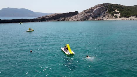 Mit-Freunden-In-Kos,-Griechenland,-Ein-Tretboot-Am-Paradise-Beach-Hinunterrutschen