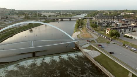 Iowa-Women-of-Achievement-Bridge-over-Des-Moines-River-in-Des-Moines,-Iowa-revealing-Iowa-state-capitol-with-drone-video-panning