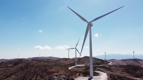 Aerial-wind-energy-park-in-greek-mountain-near-city-of-Veroia-during-beautiful-sunny-day-with-blue-sky,-Greece