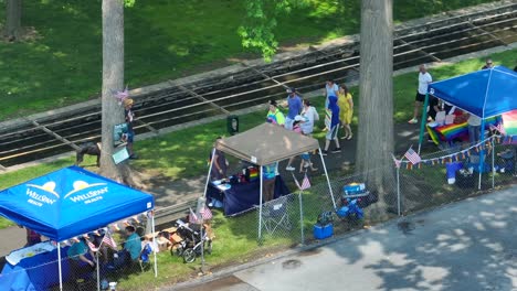 Aerial-top-down-shot-pedestrian-visiting-LGBTQ-Pride-Festival-with-stall-at-sunlight---Establishing-drone-shot