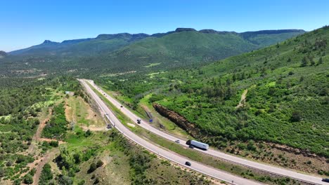 Wide-shot-of-highway-carving-through-Rockies-in-Colorado