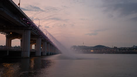 Puente-Banpo-Fuente-De-Arco-Iris-A-La-Luz-De-La-Luna-Durante-El-Crepúsculo-En-El-Colorido-Atardecer,-Seúl,-Corea-Del-Sur