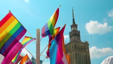 Coloridas-Banderas-Del-Orgullo-Ondeando-En-La-Brisa-Con-El-Palacio-De-La-Cultura-Y-La-Ciencia-En-La-Parte-Trasera