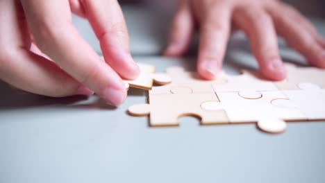 Closeup-hand-of-woman-connecting-jigsaw-puzzle,-Business-solutions,-success-and-strategy-concept