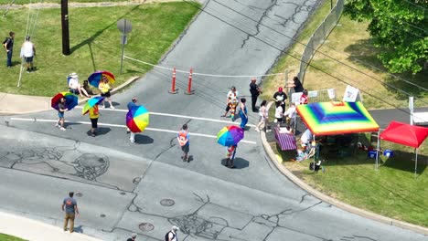 Aerial-top-down-shot-of-happy-people-entering-LGBT-Pride-Festival-during-sunny-day-in-USA---orbit-slow-motion-shot