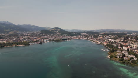 Vista-Aérea-Del-Lago-De-Lucerna-Con-El-Horizonte-De-La-Ciudad-Distante,-Suiza