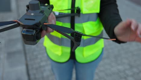 Unrecognizable-female-drone-pilot-holds-drone-for-photogrammetry-and-deploys-propellers