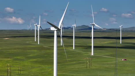 Long-aerial-shot-of-many-wind-turbines-spinning-at-wind-farm-in-American-Great-Plains