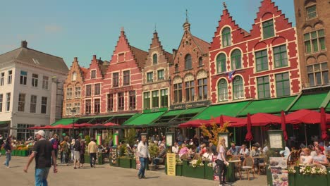 Tourists-visiting-the-main-square-grand-place-restaurants-in-Bruges,-Belgium