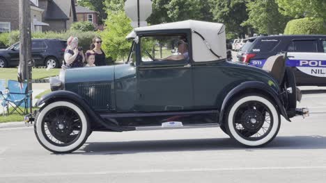 Classic-green-car-with-white-tires-at-a-parade
