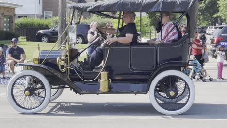 Old-antique-car-driving-down-a-festival