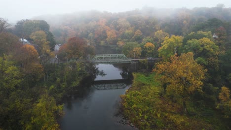Tiny-two-lane-bridge-from-drone-on-foggy-morning-with-amazing-autumn-colors-in-Delaware-at-Brecks-Mill-Brandywine-River