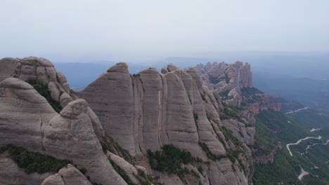 Aerial-shot-of-the-close-surroundings-of-the-unique-mountain-shapes-close-to-the-Monestary-of-Montserrat-in-Spain,-Europe