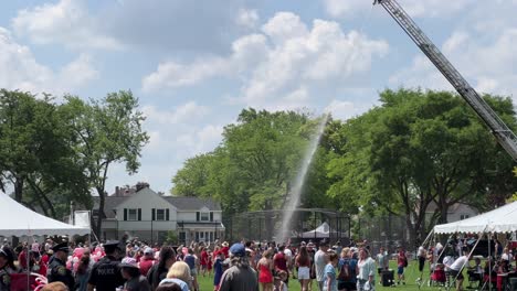 People-being-cooled-off-by-a-fire-truck-canon-on-a-ladder