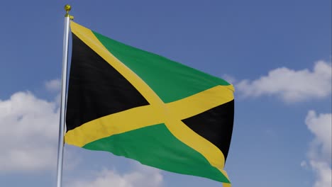 Flag-Of-Jamaica-Moving-In-The-Wind-With-A-Clear-Blue-Sky-In-The-Background,-Clouds-Slowly-Moving,-Flagpole,-Slow-Motion