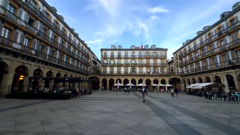 Panorama-Weitwinkelaufnahme,-Die-Den-Historischen-Verfassungsplatz-Von-San-Sebastian-Mit-Touristen-Und-Menschen-Im-Restaurant-Zeigt-–-Wunderschöne-Alte-Gebäude-In-Spanien-–-Schwenkaufnahme