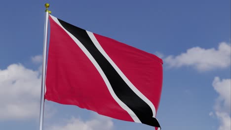 Bandera-De-Trinidad-Y-Tobago-Moviéndose-En-El-Viento-Con-Un-Cielo-Azul-Claro-En-El-Fondo,-Nubes-Moviéndose-Lentamente,-Asta-De-Bandera,-Cámara-Lenta