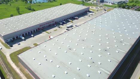 Aerial-view-of-distribution-center,-drone-photo-of-industrial-logistics-zone,new-super-modern-logistics-center-full-of-modern-technology-and-robotics,roof-solar-power-plant-for-green-energy-production