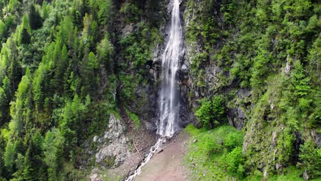 Zoom-out-footage-of-a-beautiful-waterfall-and-trees-on-a-mountain-side