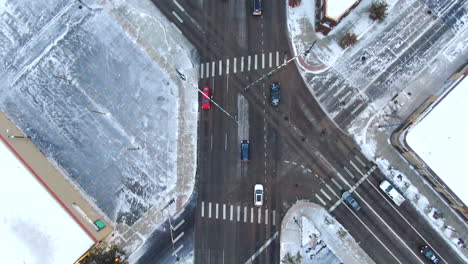 Aerial-cinematic-drone-birds-eye-view-looking-down-downtown-Denver-Colorado-city-buildings-snowing-freezing-cold-winter-day-gray-bird-dramatic-city-landscape-forward-follow-car-traffic