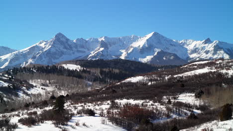 Winter-fresh-snowfall-winter-Rocky-Mountains-Ouray-Telluride-Silverton-14er-Mt-Sneffels-Dallas-Peaks-million-dollar-highway-Southern-Colorado-most-scenic-mountain-landscape-view-cinematic-pan-left