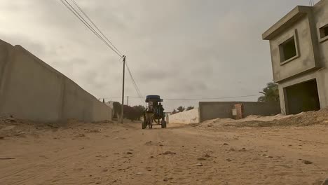 Back-tracking-shot-of-harnessed-horse-pulling-carriage-with-tourists-for-tour-in-Tunisia