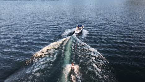 knee-boarder-on-lake-arrowhead-mooning-camera-behind-boat-AERIAL-FOLLOW